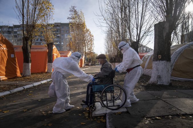 Virus Outbreak Overwhelmed Ukraine Medical staff in protective gear transport an elderly patient suspected of having COVID 19 in a wheelchair at a tent hospital erected to care for coronavirus patients in Kakhovka, Ukraine, on Sunday, Nov. 7, 2021. Ukraine, with one of Europe's lowest vaccination rates and a struggling and underfunded health care system, is setting records almost daily for coronavirus infections and deaths.