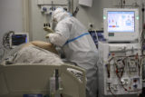 Virus Outbreak Russia A medical staff member wearing a special suit to protect against COVID 19 treats a patient with coronavirus at an ICU at the Regional Clinical Hospital 1, in Krasnodar, south Russia, Tuesday, Nov. 2, 2021. Coronavirus deaths in Russia hit another daily record several days after a nationwide order for many Russians to stay off work took effect. Russia's state coronavirus task force has reported record daily infections or deaths almost every day for the last month.