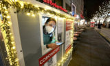 Europe Economy FILE - Coronavirus test center employee Denise waits for clients on the famous 'Kurfuerstendamm (Ku'damm)' shopping road in Berlin, Germany, on Dec. 21, 2021. The risk of recession is looming for Germany after Europe’s biggest economy shrank at the end of 2021 and as it faces a bumpy start to this year. The rapid spread of COVID 19's omicron variant is deterring people from shopping and travel and supply bottlenecks are holding back manufacturers. The state statistics agency said Friday, Jan. 14, 2022 that output in Germany fell by between 0.5% and 1% in the fourth quarter.