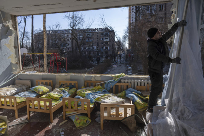 APTOPIX A man removes a destroyed curtain inside a school damaged among other residential buildings in Kyiv, Ukraine, Friday, March 18, 2022. Russian forces pressed their assault on Ukrainian cities Friday, with new missile strikes and shelling on the edges of the capital Kyiv and the western city of Lviv, as world leaders pushed for an investigation of the Kremlin's repeated attacks on civilian targets, including schools, hospitals and residential areas Russia Ukraine War