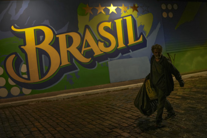 A homeless walks past a mural of Brasil at the Vila Madalena neighborhood in Sao Paulo, Brazil