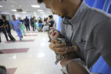 Palestinian child wounded in Israel strikes are brought to Shifa Hospital in Gaza City on Wednesday